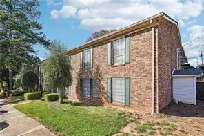 View of front of house with brick siding and a front lawn