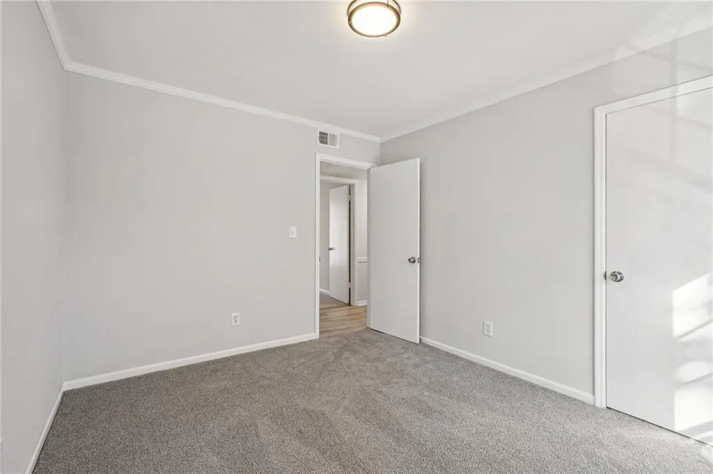 Unfurnished bedroom featuring ornamental molding and carpet flooring