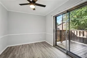 Unfurnished room with wood finished floors, ornamental molding, baseboards, and ceiling fan