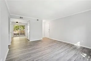 Unfurnished living room featuring wood finished floors and baseboards