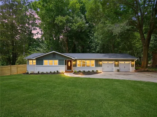 Single-story exterior with a two-car garage, established front landscaping, and a wood privacy fence