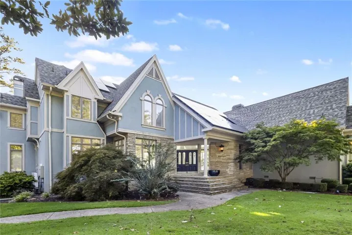 Stucco and stone exterior featuring multiple gables and a covered entry