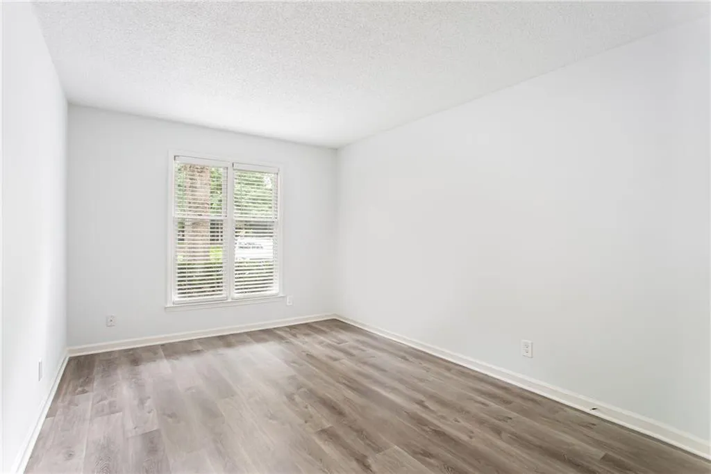 Empty room with a textured ceiling and light wood-style floors