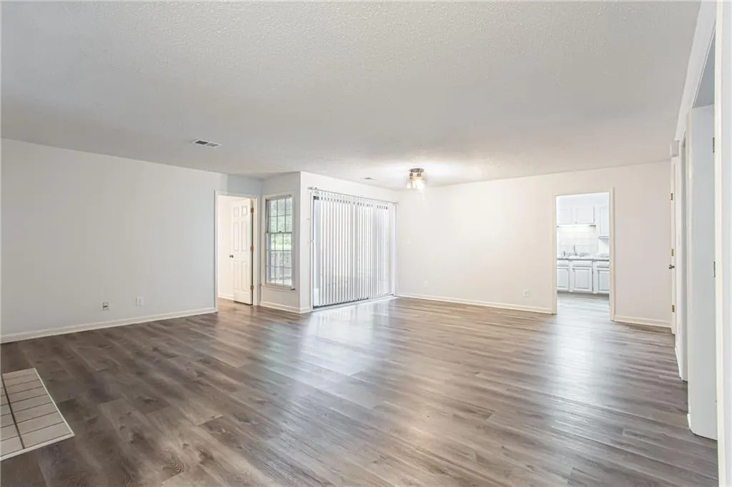 Spare room with a textured ceiling and dark wood-style floors