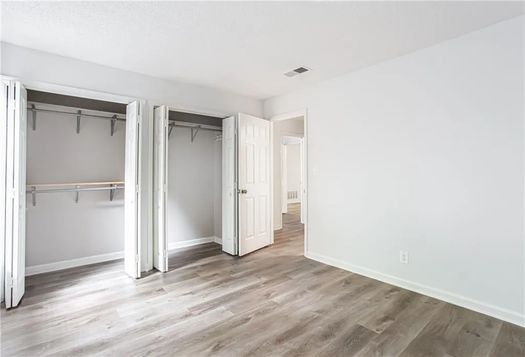 Unfurnished bedroom featuring multiple closets and light wood-style floors