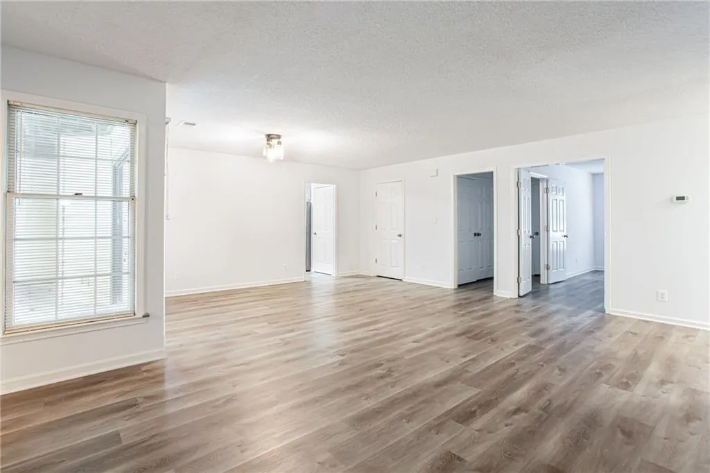 Unfurnished room with a textured ceiling and light wood finished floors