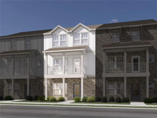 Three-story townhome with a brick and vertical siding exterior, featuring multiple balconies with white railings and an arched front door