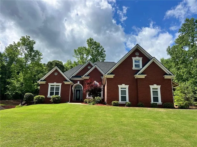 Traditional-style home featuring brick siding and a level front yard