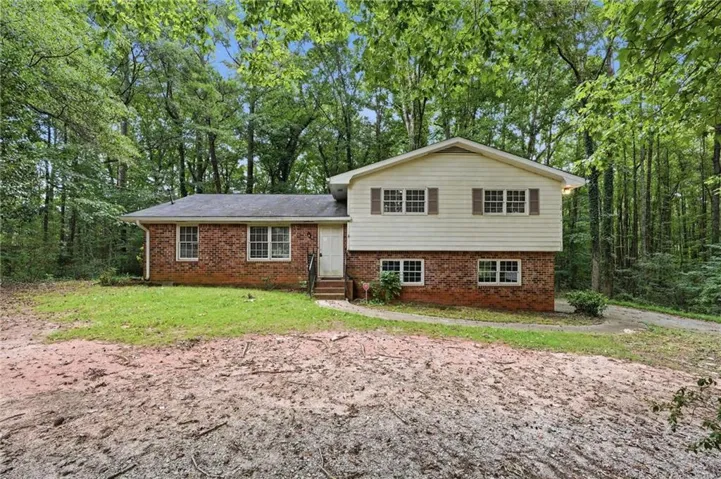 Two-story residence featuring a brick and siding exterior, multiple windows with shutters, and a front entry with steps