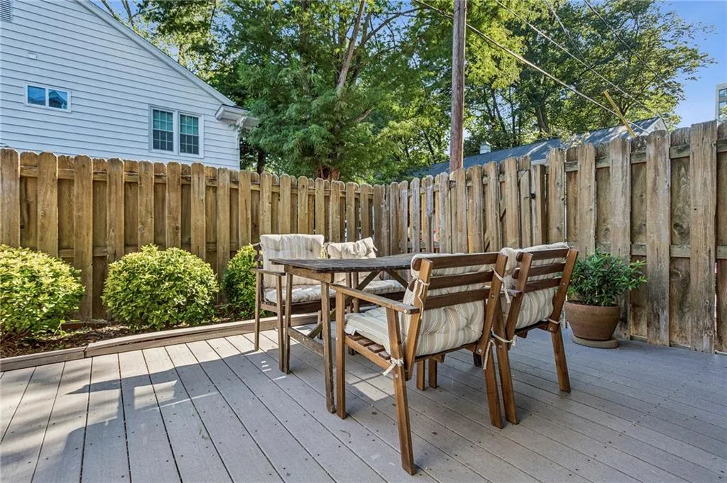 Wooden deck with outdoor dining space and a fenced backyard