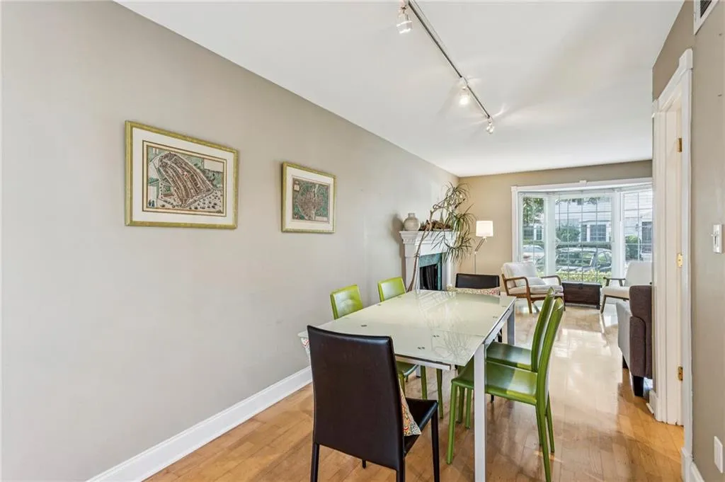 Dining room featuring rail lighting, a fireplace, and light wood-type flooring
