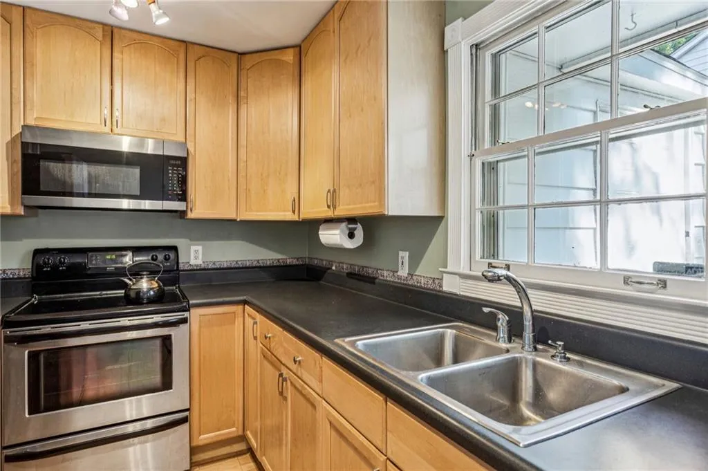 Kitchen featuring appliances with stainless steel finishes, plenty of natural light, and dark countertops