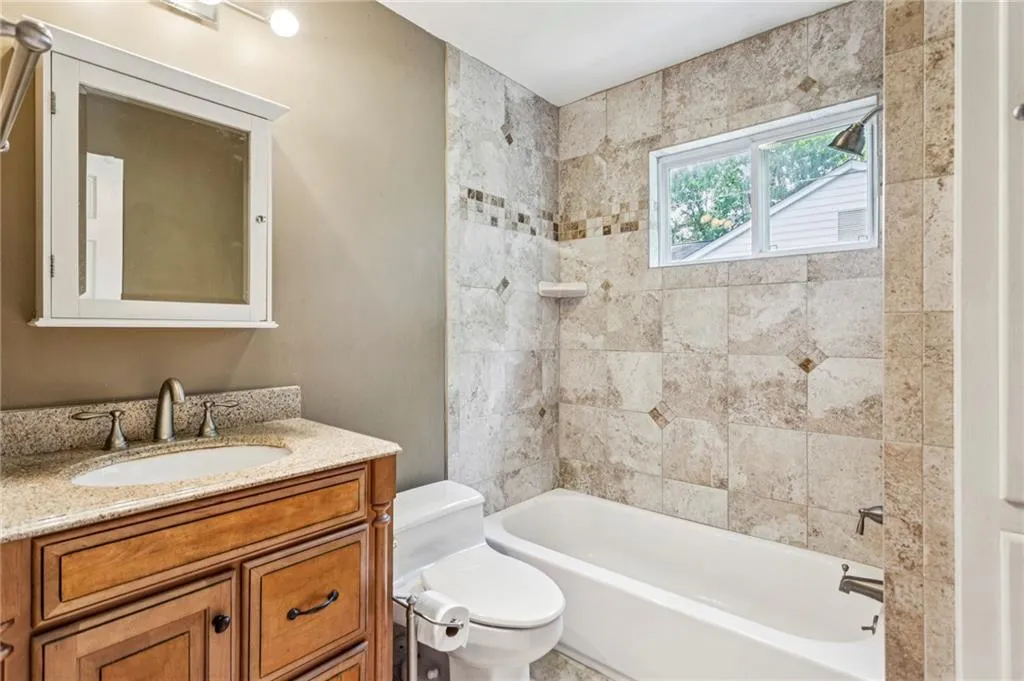 Bathroom featuring vanity and washtub / shower combination