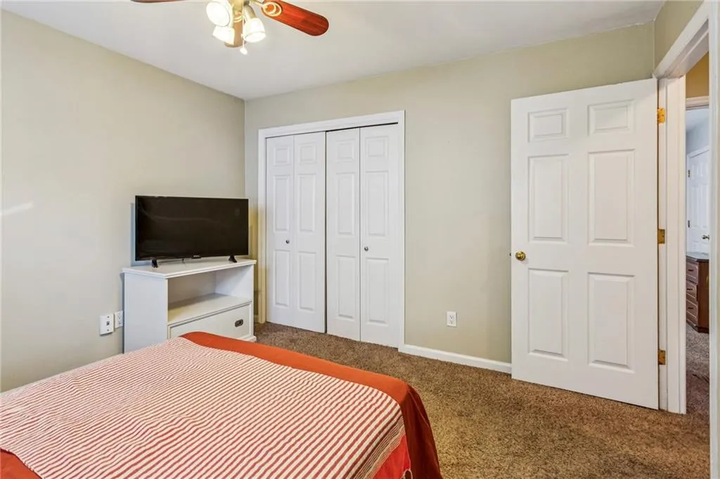 Bedroom with carpet flooring, a closet, and a ceiling fan
