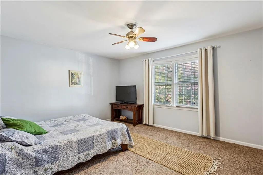 Carpeted bedroom featuring baseboards and ceiling fan