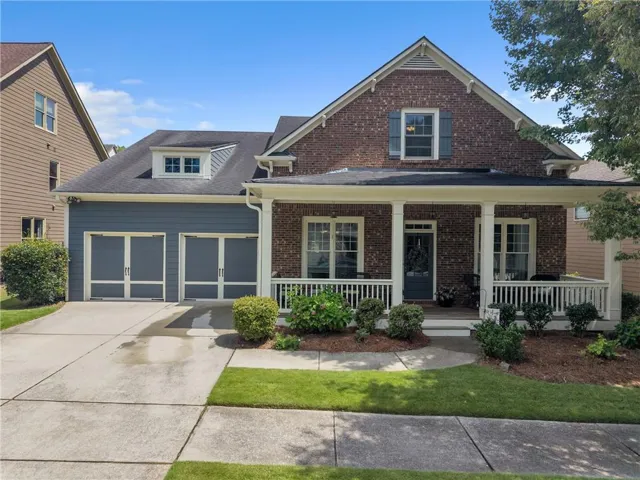 Brick exterior with a covered front porch featuring white columns and railing