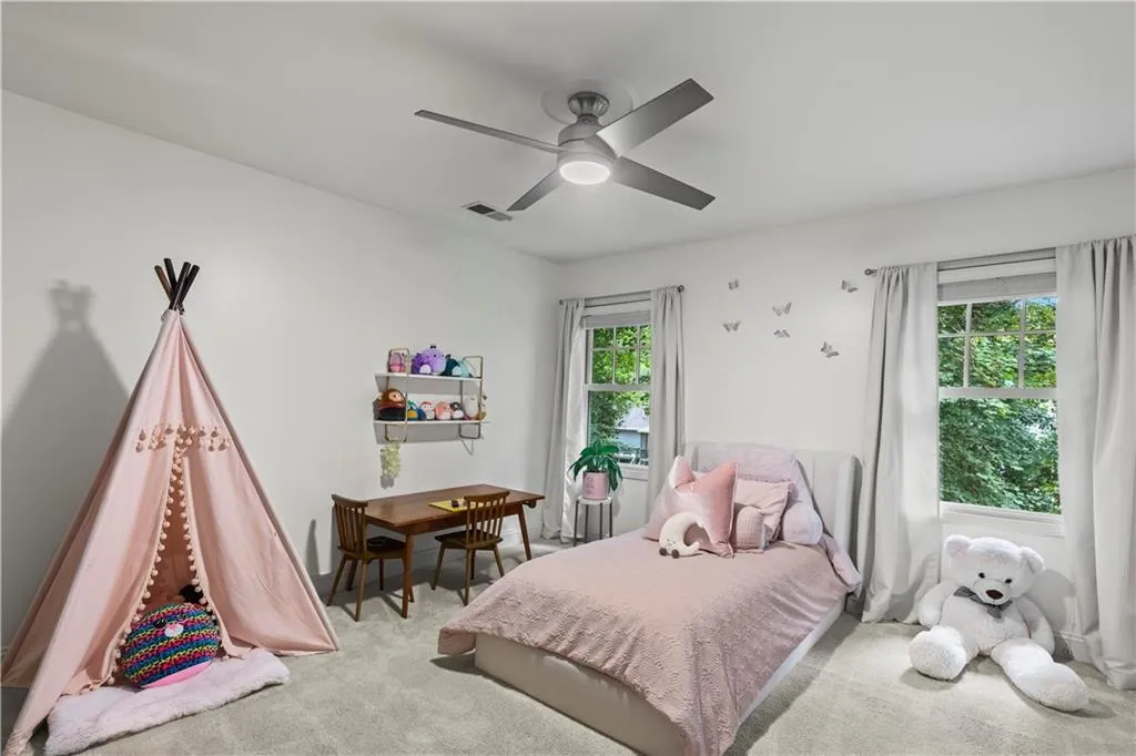 Carpeted bedroom featuring a ceiling fan