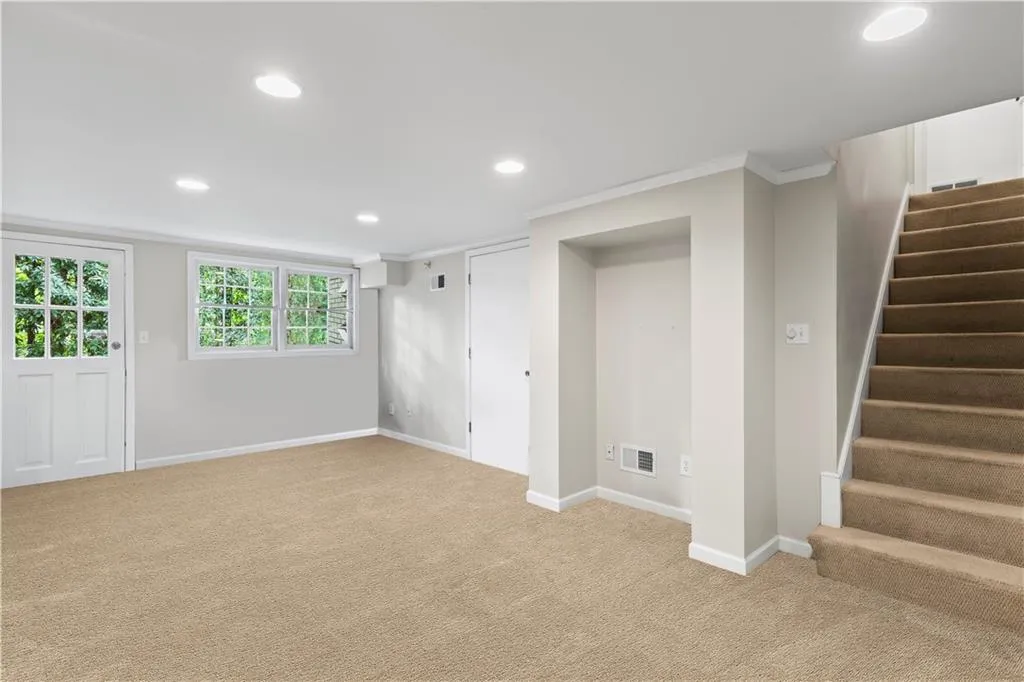 Below grade area featuring recessed lighting, stairway, carpet floors, and crown molding