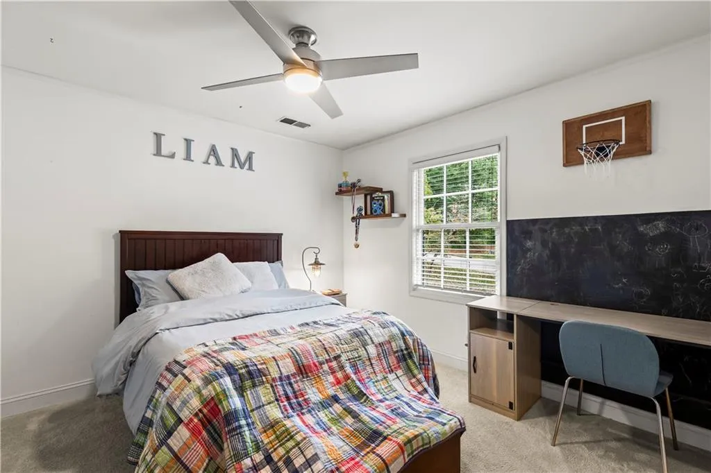 Bedroom with light carpet and a ceiling fan