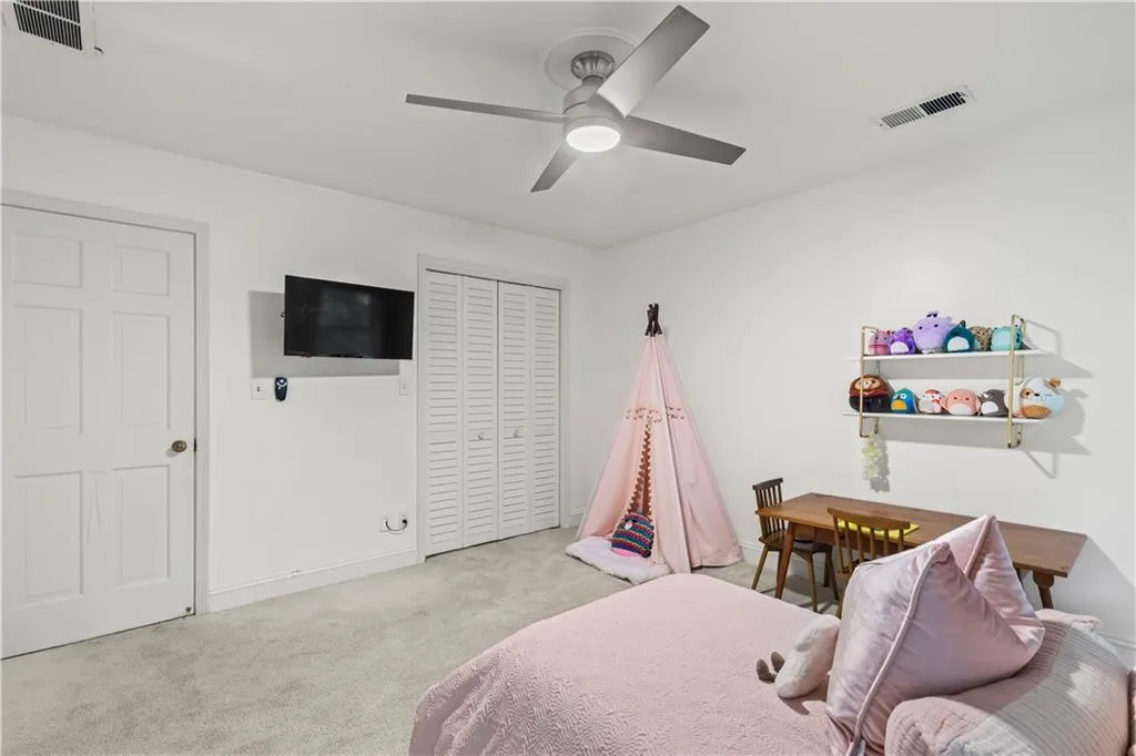 Bedroom with carpet, ceiling fan, and a closet