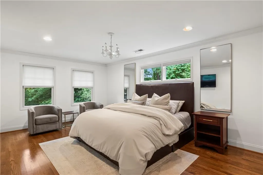 Bedroom featuring ornamental molding, dark wood-type flooring, a chandelier, and recessed lighting