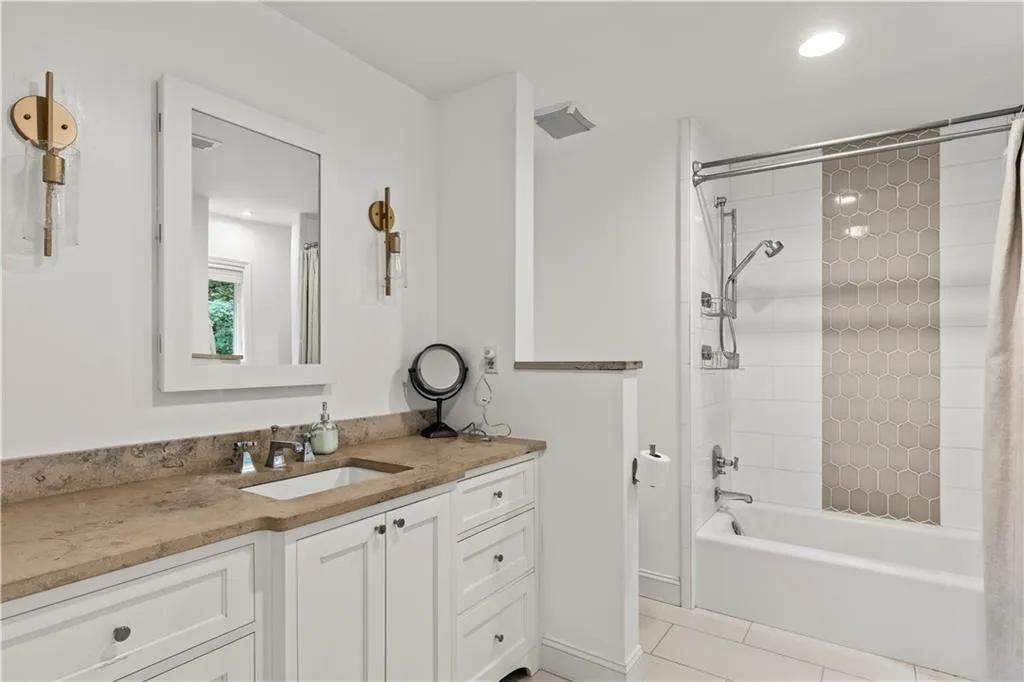 Bathroom featuring vanity, bathing tub and / shower combination, light tile patterned floors, and recessed lighting