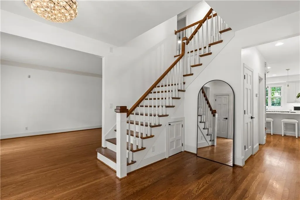 Stairway with wood finished floors, a chandelier, and recessed lighting