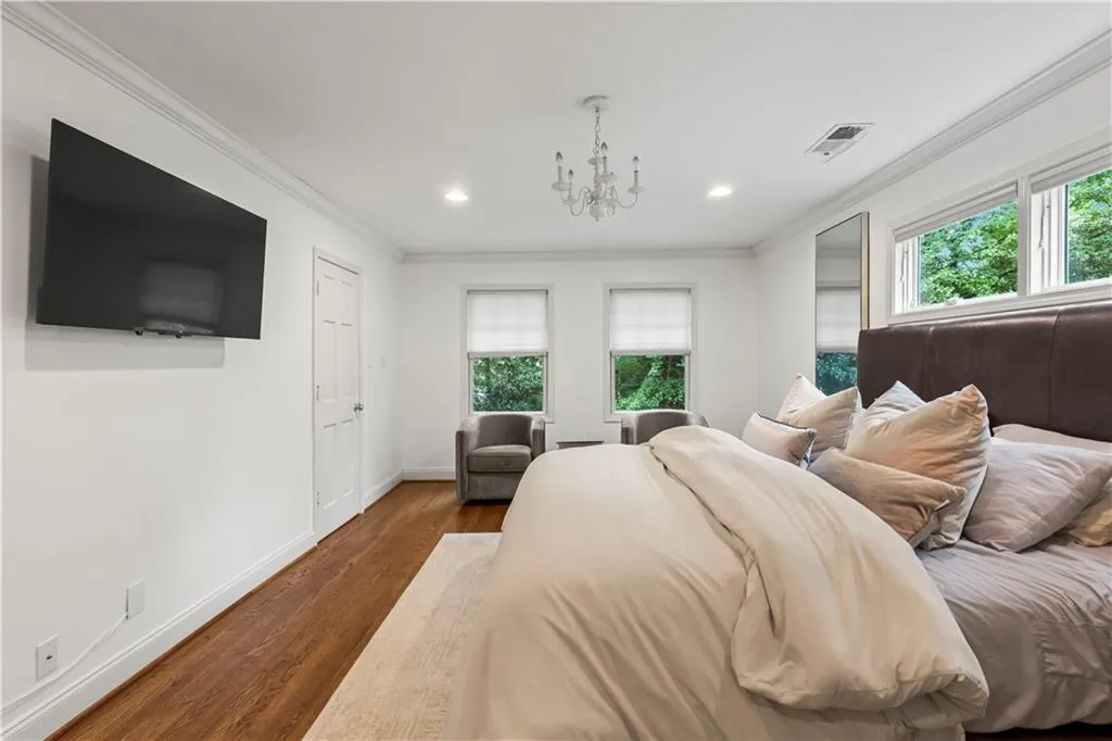 Bedroom featuring wood finished floors, crown molding, a chandelier, and recessed lighting
