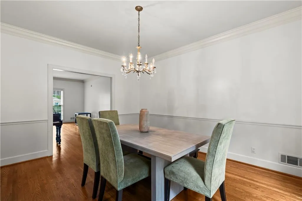 Dining room featuring crown molding, wood finished floors, and a chandelier