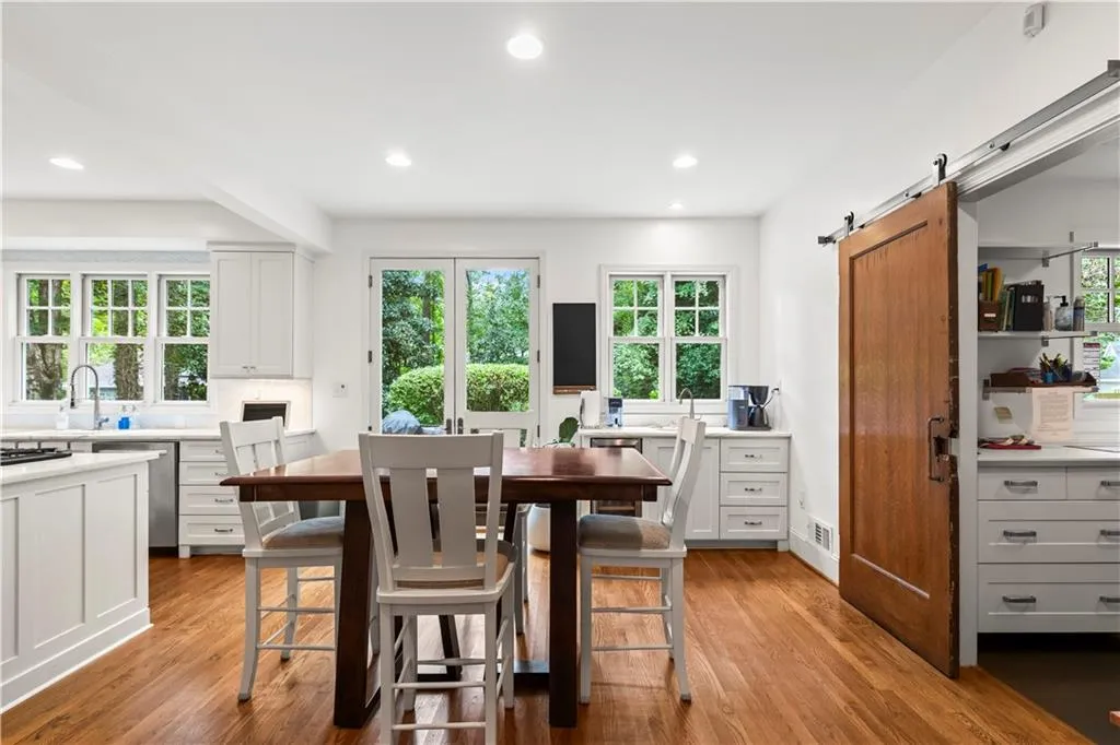 Dining space with light wood-style floors, recessed lighting, a barn door, and healthy amount of natural light