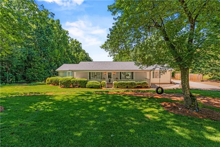 Ranch-style exterior with a covered porch and white railings