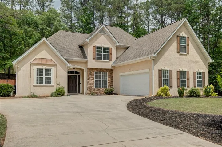 Stucco exterior with stone accent facade and dark wood shutters
