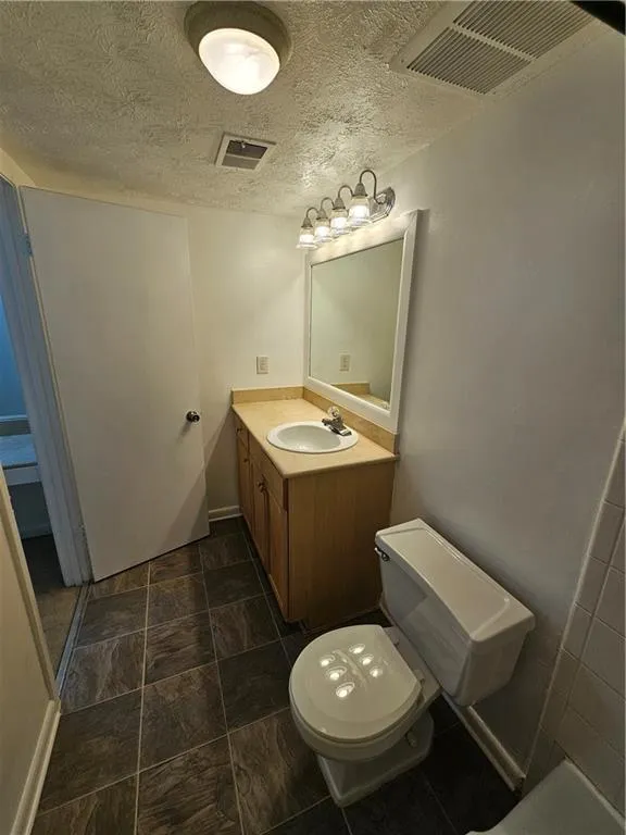 Bathroom with vanity and a textured ceiling