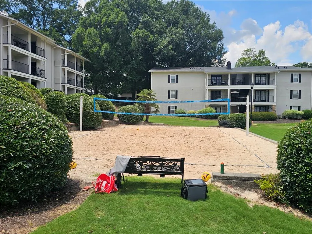 View of property's community featuring a lawn and volleyball court