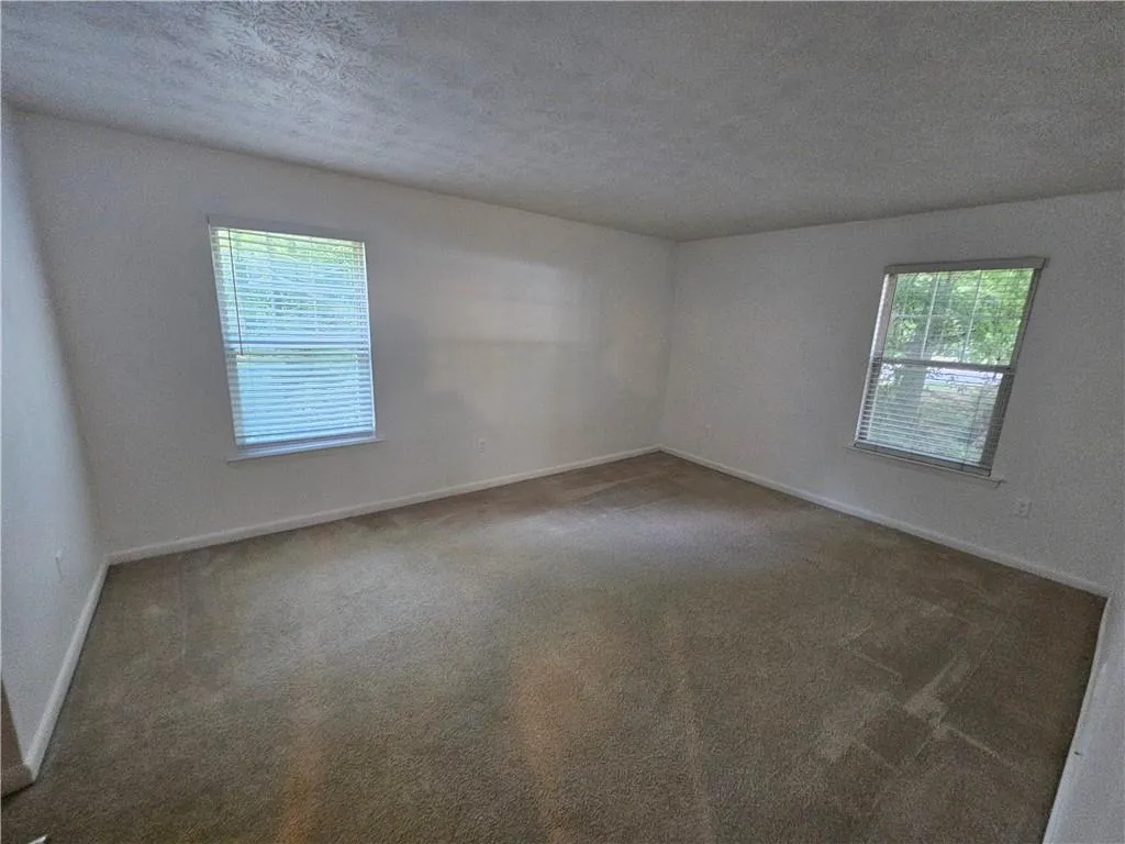 Masterbedroom featuring carpet flooring and a textured ceiling