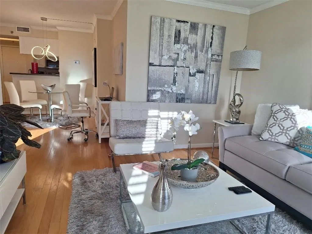 Living room with crown molding and hardwood / wood-style floors