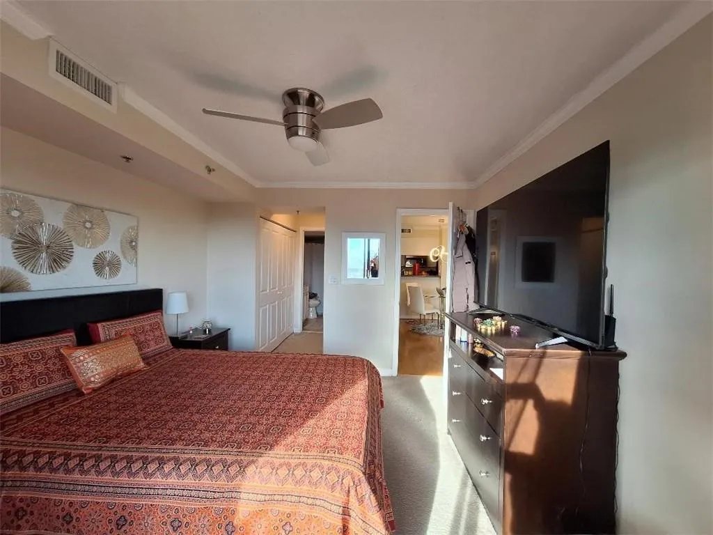 Bedroom featuring carpet floors, a closet, crown molding, a ceiling fan, and ensuite bathroom