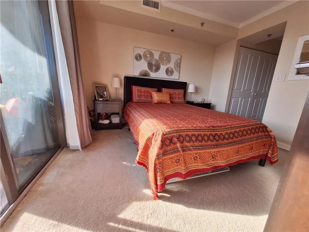 Carpeted bedroom featuring a closet and crown molding