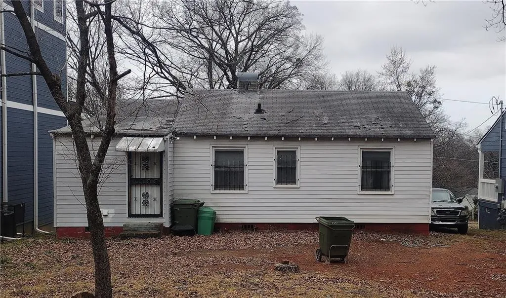 Back of house with roof with shingles and crawl space