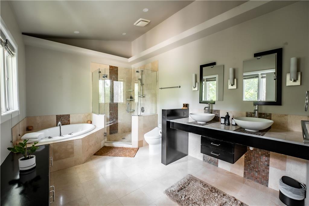 Bathroom with tile floors, dual vanity, plus walk in shower, and vaulted ceiling