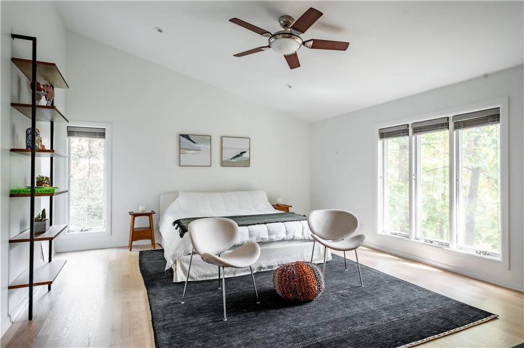 Bedroom featuring multiple windows, light hardwood / wood-style floors, and ceiling fan