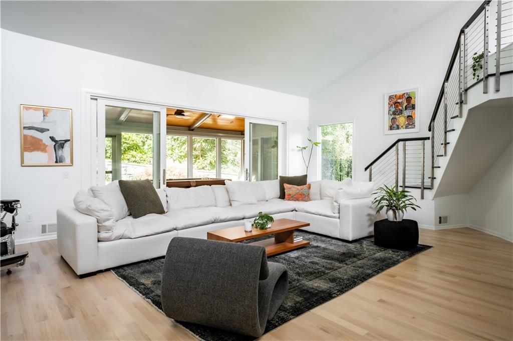 Living room featuring light wood-type flooring and high vaulted ceiling