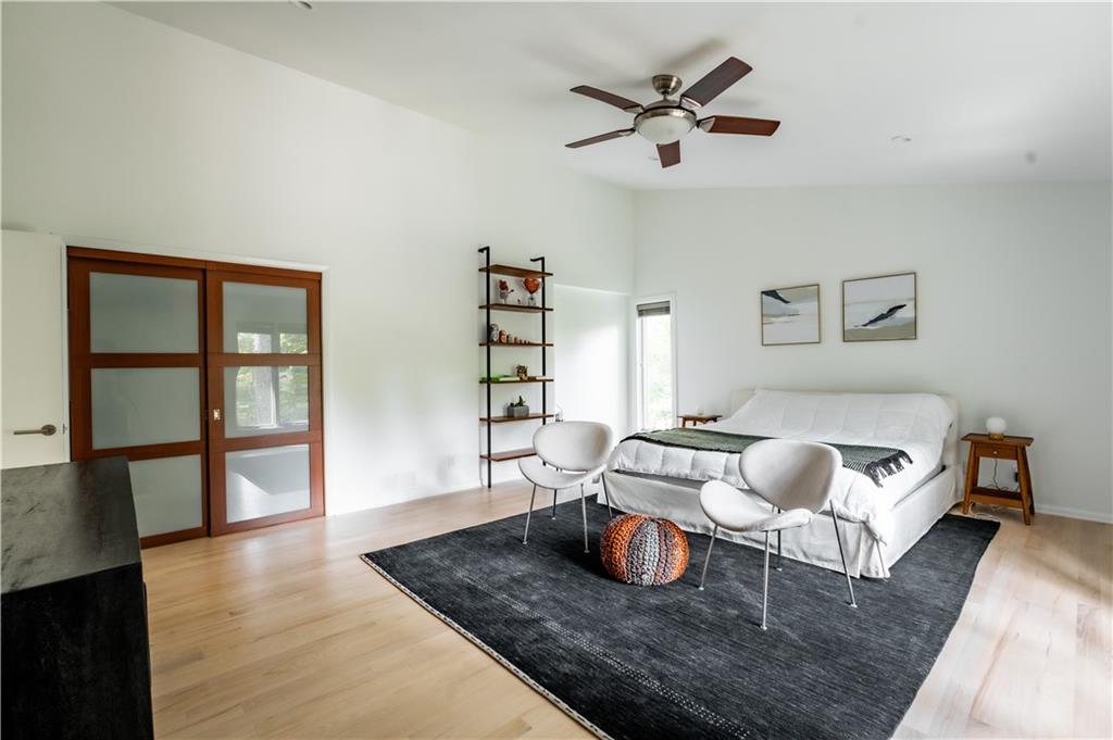 Bedroom featuring vaulted ceiling, light hardwood / wood-style floors, and ceiling fan