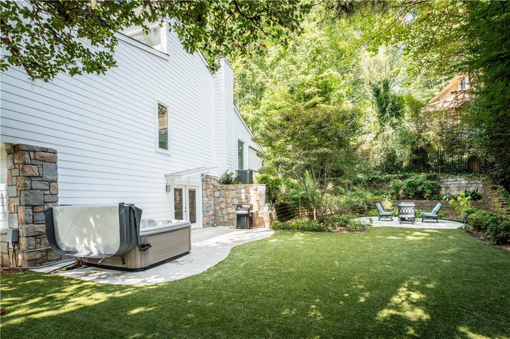 View of yard with a hot tub and a patio