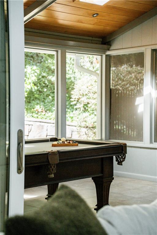 Rec room with light tile floors and wooden ceiling