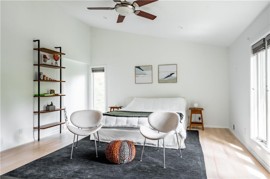 Bedroom featuring lofted ceiling, light hardwood / wood-style flooring, and ceiling fan