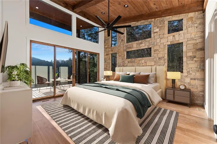 Owners Bedroom with Rock Feature Wall + Vaulted Stained Ceilings + Slider Doors to Deck + Lake