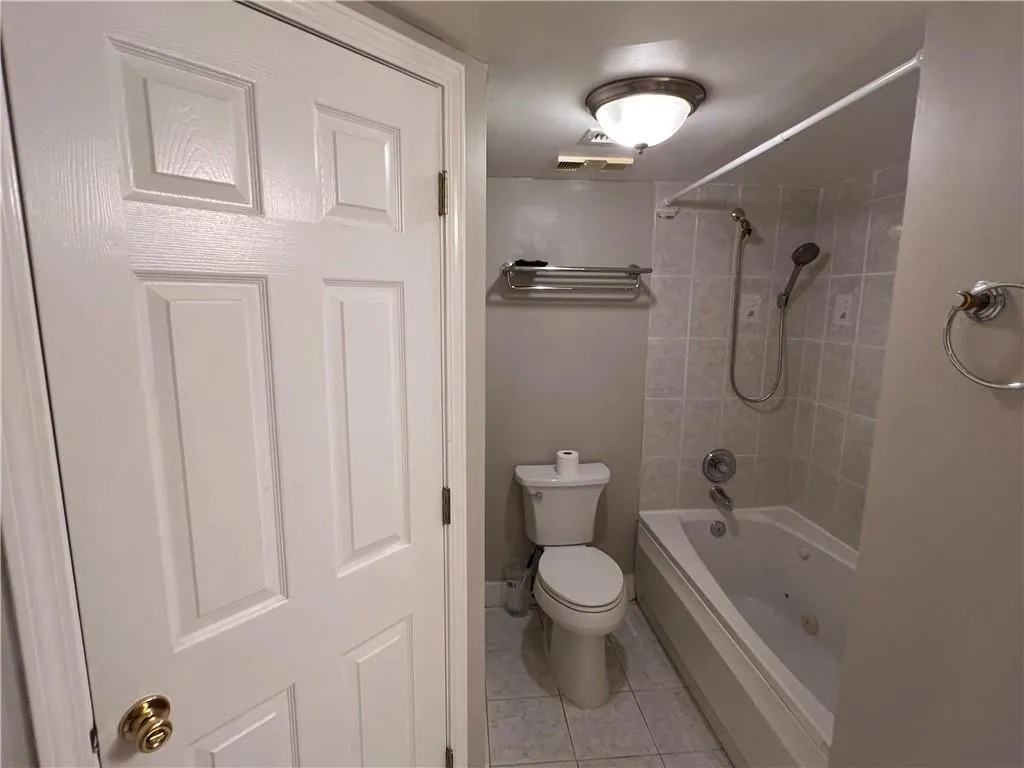 Bathroom featuring tile patterned flooring and a combined bath / shower with jetted tub