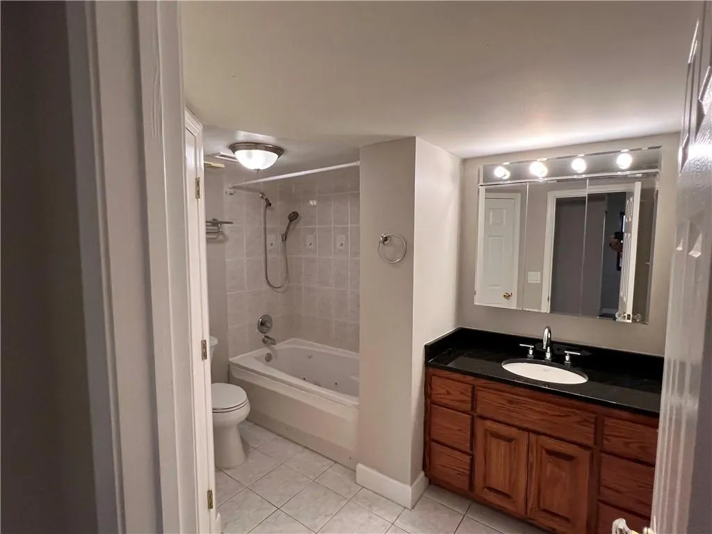 Bathroom featuring tile patterned floors, vanity, and bathtub / shower combination