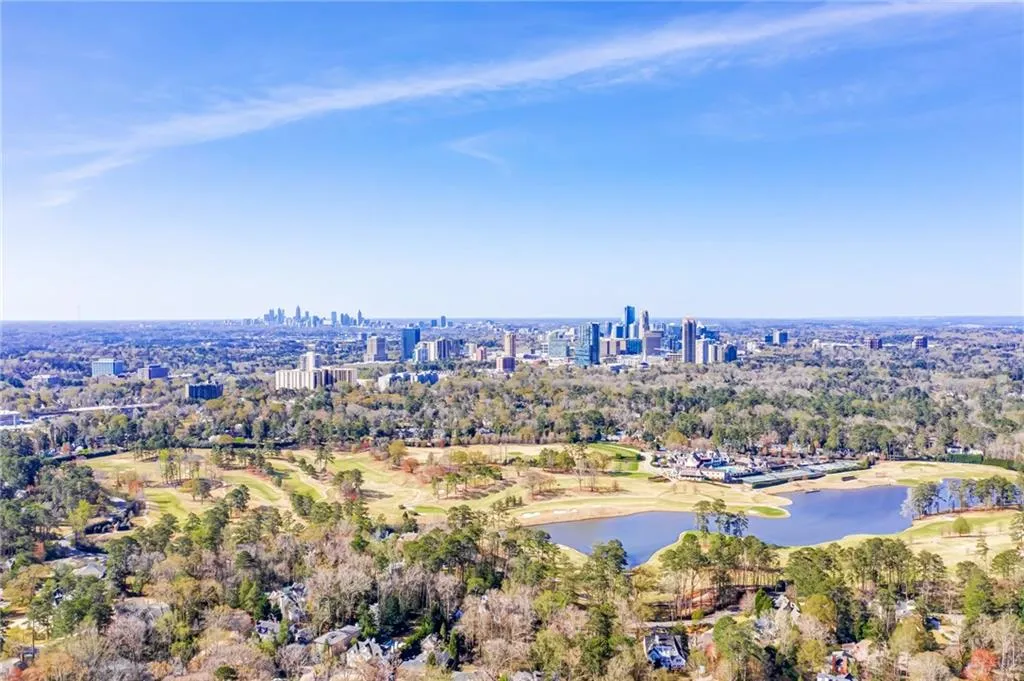 Aerial view of property and surrounding area with a nearby body of water and a local golf course